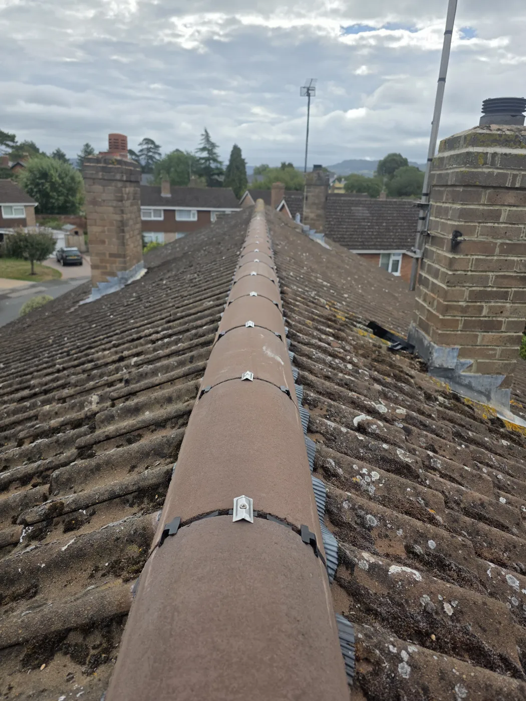 New ridge tiles clipped in place along the length of a tiled roof